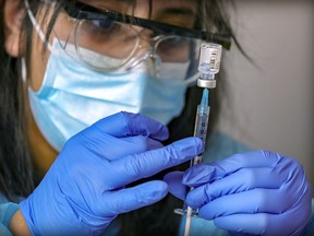 A nurse prepares a COVID-19 vaccine