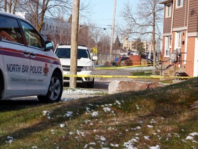 Police tape and vehicles are seen, Saturday morning, around homes at a residential complex on Manitou Street after a shooting the previous night. Michael Lee/The Nugget