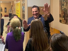 Nickel Belt MP Marc Serre high-fives students during a pre-pandemic visit to Ecole Ste-Marie in Azilda.
