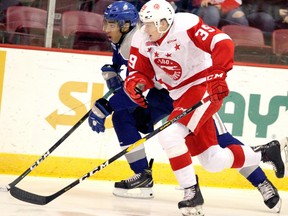 Soo Greyhounds forward Brett Jacklin (39) races to a puck against Sudbury Wolves forward Quinton Byfield (55) during first-period Ontario Hockey League action at GFL Memorial Gardens in Sault Ste. Marie, Ontario on Wednesday, Nov. 21, 2018.