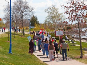 About 75 people march along the North Bay Waterfront, Saturday, as part of a 'Freedom Rally' protesting COVID-19 restrictions. Michael Lee/The Nugget