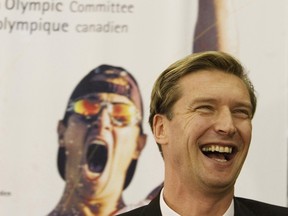 Canadian two-time gold-medal winner Alex Baumann speaks to reporters, in front of poster of fellow Olympic medal-winning paddler Adam Van Koeverden, after being hired to help run the 2008 Canadian Olympic team for the Beijing Olympic Games. Baumann now serves as CEO of Swimming Australia.
