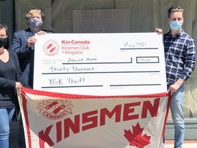 Elizabeth Suurd, YGK Thrift store manager, and Sam MacLeod, Almost Home's fund development manager, accept a cheque for $30,000 from Joel Thompson on behalf of the Kinsmen Club of Kingston outside the new 165 Princess St. location on May 14.