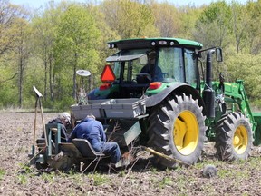 Jim Gould and Stu Sharp are pictured planting trees at Fairbank Oil Fields in Oil Springs earlier this month, as Wally Van Dunn slowly drives the tractor forward. The reforestation project between Fairbank Oil and the St. Clair Region Conservation Authority included planting 13,370 trees in 2020 and 2021. (Submitted)