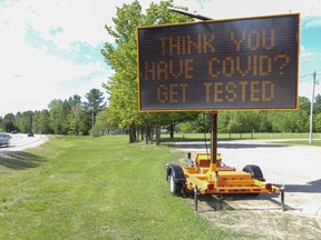 Motorists pass a sign urging COVID-19 testing Monday, June 1, 2020 in L'Amable, south of Bancroft.