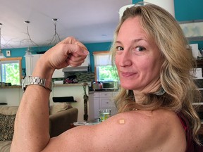 Nadine Robinson flexes with her post vaccination bandage, as getting the vaccine makes communities stronger.