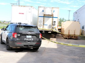 Sault Ste. Marie Police Service keeps watch of a dumpster where a woman was found dead on Friday, May 28, 2021 in Sault Ste. Marie, Ont. (BRIAN KELLY/THE SAULT STAR/POSTMEDIA NETWORK)