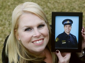 Sarah Routhier holds a photo of her late husband, OPP Sgt. Sylvain Routhier, outside their Belleville home. Working to raise awareness of mental-health issues and increase support has helped in her healing since his 2018 suicide, she says.