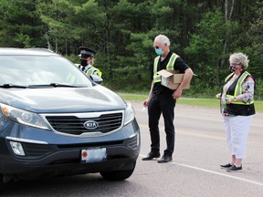 Staff Sgt. MaryAnn MacNeil of the Upper Ottawa Valley detachment of the Ontario Provincial Police speaks with a driver on Paquette Road near Montgomery Road during the Mega RIDE on May 21. Looking on are Petawawa Coun. James Carmody, chairman of the Petawawa Police Services Board and board member Sharon Dainty, who were handing out small gifts to sober drivers.