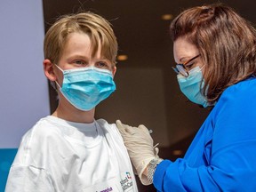 Charles Muro, 13, is inoculated by nurse Karen Pagliaro at Hartford Healthcare's mass vaccination centre at the Connecticut Convention Center in Hartford, Conn., on May 13, 2021. Ontario plans to allow children aged 12 to 17 to begin booking vaccination appointments the first week of June.  (Photo by JOSEPH PREZIOSO/AFP via Getty Images)