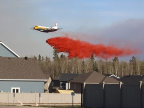 A waterbomber spraying the area near Stone Creek, from Prospect Drive, in Fort McMurray Alta., May 1, 2016. Stephanie Jellett/ Fort McMurray Today/ Postmedia Network