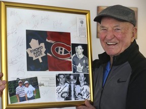 NHL legend Dick Duff holds up a framed Habs-Leafs memento signed by the two teams after they their last game at the Montreal Forum. Duff won six Stanley Cups between the two teams. JACK BOLAND/TORONTO SUN