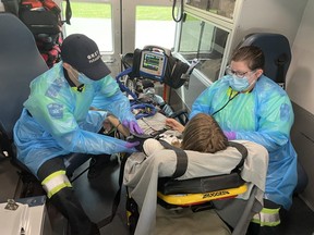 Grey County paramedics Tristan Baker, left, and Bradi Watson assess a "patient" in the back of an ambulance Tuesday during Paramedic Services Week in Ontario. SUPPLIED