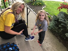 Hope Jennions, 6, helps her mom Abbey Ball with her laces before a training session. Ball is among 10 Brantford and area residents who will be walking 100 kilometres in 24 hours in support of her daughter and others who live with Cystic Fibrosis.