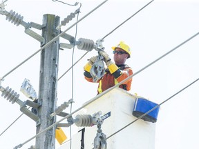 London Hydro lineman Bryan Snyder upgrades power lines along William Street in London. About 10 per cent of London Hydro customers have made the switch from time of use to tiered pricing. (Derek Ruttan/The London Free Press)