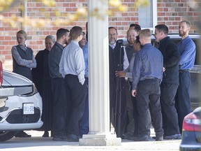 Pastor Henry Hildebrandt (centre with grey beard) is surrounded by congregants at the Church of God in Aylmer on Friday, hours after a judge ordered the church's doors padlocked following several large Sunday services in breach of Ontario's pandemic restrictions. Derek Ruttan/The London Free Press/Postmedia Network