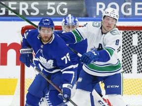 Toronto Maple Leafs' T.J. Brodie (78) defends in front of the net with Vancouver Canucks' Brock Boeser (6) during the second period in Toronto on Thursday, April 29, 2021. Jack Boland/Toronto Sun/Postmedia Network