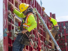 Brandon McPherson and Dillon Needham of EllisDon work on a new tower being built by York Developments at the southwest corner of the Springbank Drive-Wonderland Road intersection in London. Photograph taken on Thursday May 6, 2021. Mike Hensen/The London Free Press/Postmedia Network