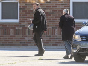 Church of God Pastor Henry Hildebrandt arrives at the Aylmer church Thursday morning, where he was joined by dozens of congregants, just as a nearby court was deliberating whether its doors should be looked due to flagrant defiance of Ontario's laws against indoor gatherings amid COVID-19. Photo taken May 13, 2021. (Mike Hensen/The London Free Press)