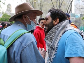 A Palestine supporter, left, faces an Israel supporter during a protest in front of Toronto City Hall, Saturday, May 15, 2021.