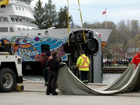 Men wait with a tarp to cover a van which was pulled out of the harbour Sunday afternoon in Owen Sound as part of a sudden death police investigation. (Scott Dunn/The Sun Times/Postmedia Network)