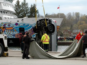 Men wait with a tarp to cover a van which was pulled out of the harbour Sunday afternoon in Owen Sound as part of a sudden death police investigation. (Scott Dunn/The Sun Times/Postmedia Network)