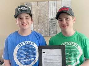 Seventeen-year-old Aidan Forbes, with his twin brother, Owen, holds a proclamation declaring May 14 Apraxia Awareness Day in Brantford. The brothers were born with childhood apraxia of speech.