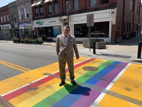 Brant Mayor David Bailey stands on Pride flag coloured crosswalk on Grand River Street North, between Mechanic and William streets, in downtown Paris, that was damaged with tire marks days after it was unveiled on May 13. Plans call for it to be repaired by the start of Pride Month on June 1.