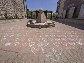 In Cobblestone Common Park, nestled between downtown businesses in Paris, Ontario 215 hearts have been drawn with chalk, and footwear placed by a stone sculpture in memory of the 215 children whose remains were found in a mass grave at a former residential school site in Kamloops, B.C.