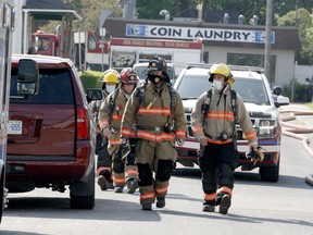 Augusta Township firefighters walk up Hamilton Street, providing reinforcement to Brockville firefighters battling a structure fire on Wednesday. (RONALD ZAJAC/The Recorder and Times)
