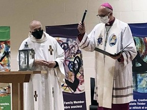 Bishop Joseph Dabrowski (right) assisted by Father Jim Higgins, leads a virtual service of blessing for St. Angela Merici Catholic School in Chatham on May 6.