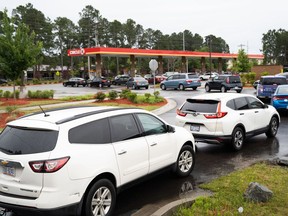 Motorists wait in line at a gas station on May 12, 2021 in Fayetteville, North Carolina. Most stations in the area along I-95 are without fuel following the Colonial Pipeline hack. The 5,500-mile long pipeline delivers a large percentage of fuel on the East Coast from Texas up to New York.