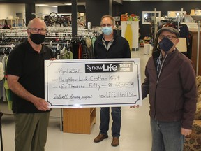 George Flikweert, left, a volunteer with the newLIFE Thrift Store in Chatham, presents a donation of $6,050 from sales proceeds Harold VanderEnde, right, chair of NeighbourLink, for the Indwell housing project. Also pictured is Al Baker, network co-ordinator for NeighbourLink. Ellwood Shreve/Chatham Daily News/Postmedia Network