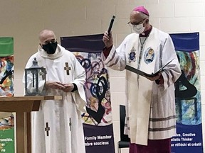 Bishop Joseph Dabrowski, right, assisted by Father Jim Higgins, leads a virtual service of blessing for St. Angela Merici Catholic School in Chatham on Thursday.