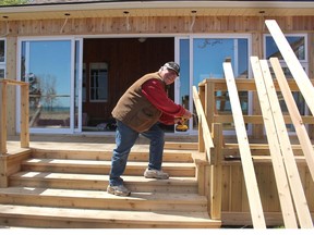 Gerry Teahen, of Exeter, was busy Wednesday working on a new deck he's added to his cottage at Rondeau Provincial Park, along with some new sliding windows along the back wall that provide a great view of Lake Erie. Ellwood Shreve/Chatham Daily News/Postmedia Network