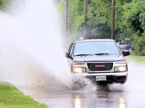 A pickup truck drives through a large puddle on Baldoon Road in Chatham. (Postmedia Network file photo)