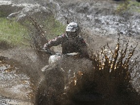 Craig Pollock hits a mud puddle on his dirt bike at McLean Creek, a popular camping and offroad use area west of Calgary on Sunday May 21, 2017. Jim Wells//Postmedia
