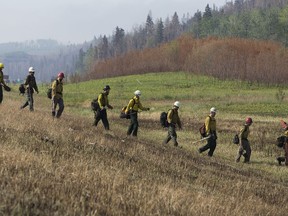 Firefighters with Alberta Forestry head into the trees along Hwy 63 north of Fort McMurray Alta. on Thursday June 2, 2016.  David Bloom/Postmedia