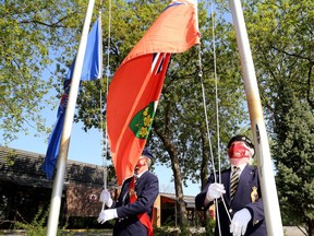 Paul Carnegie, left, sergeant-at-arms for Royal Canadian Legion Branch 560, and Scott Amey, first vice-president, raise flags on Tuesday with new rope provided by members of the public. The rope for the flagpoles was stolen last month.