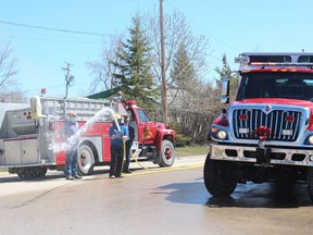 After hosing down the new truck, retired members of Carrot River Fire and Rescue attempt to hose down some of the audience as the department marked the retirement of one truck and commissioning of a brand new one. Photo Susan McNeil.