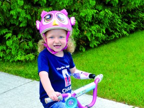 Michaela rides her bike with the help of a special device. PHoto supplied.