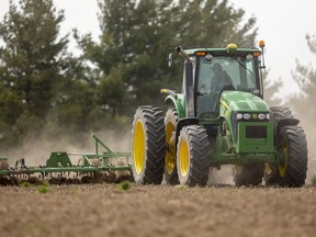 A farmer uses a cultivator on a small field destined to be planted with corn.