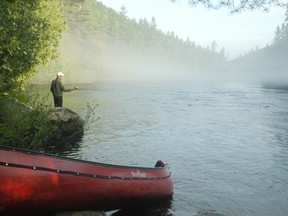 Jan Mikkelson enjoys the evening at a campsite with a fishing rod and a beautiful sunset after a day of adventure in the wilderness of the Dumoine River. credit Ralph Plath--Travel: Dumoine River, Quebec