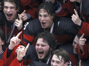 Mason McTavish (centre), of Carp, a former Pembroke Lumber King, was a member of Team Canada that won gold at the IIHF Ice Hockey U18 World Championship in Frisco, Texas May 6 with a 5-3 win over Russia. He is all smiles here as he gets his hand on the championship trophy during the team photo.