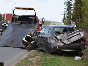Tow truck workers prepare to remove a car that was involved in a single vehicle rollover on Saturday at the intersection of Jennifer Heil Way and Nelson Drive. Depsite damage to the vehicle, no injuries were reported, but the driver was taken to hospital by ambulance as a precaution.