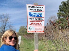 Noelle’s Gift’s Cathy Robertson ties a blue ribbon around a fence along Sarnia’s Howard Watson Trail as part of the charity’s new month-long May fundraiser, Count Your K’s in May. Handout/Sarnia This Week