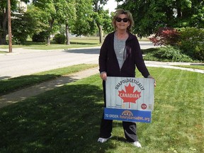 Rotary Club of Sarnia Bluewaterland member and Sarnia Canada Day committee member Becky Wellington-Horner proudly stands beside her 'Unapologetically Canadian' lawn sign, part of a patriotic fundraising campaign aimed at raising money for the Rotarians' community work and the City of Sarnia's Canada Day Committee.Carl Hnatyshyn/Sarnia This Week