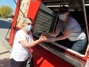 Landmark Village resident Nell Huizinga picks up an order of bridge fries from Big Daddy's Chip Truck's co-owner Nicole Courchesne on May 18. Carl Hnatyshyn/Sarnia This Week