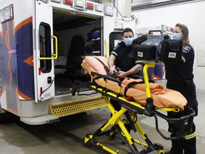 Timmins paramedics Natalie Robitaille and Ryan Roy check their equipment while loading a stretcher into an ambulance at the Cochrane District Social Services Administration building. Cochrane District is one of nine regions across the province approved for a pilot program that will see paramedics extending services to palliative care patients.

RICHA BHOSALE/The Daily Press