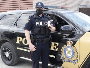 Timmins Police Const. Logan Ferrington is seen here holding up a roadside breath-screening device, commonly used by police during RIDE spot checks. Both the TPS and OPP say they will have officers out for RIDE spot checks this long weekend. Along with road safety, TPS officials say they will be monitoring neighbourhoods to ensure COVID-19 compliance. 

RICHA BHOSALE/The Daily Press